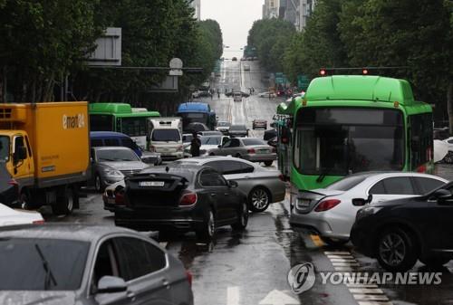 Cars abandoned by motorists amid heavy downpours and ensuing flash floods sit unattended on a road near Daechi Station in southern Seoul on Aug. 9, 2022. (Yonhap)