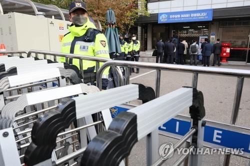 Prosecution investigators stand in front of the Democratic Party's headquarters in Seoul's Yeouido on Nov. 9, 2022, as party officials shut down the entrance in resistance to a raid.