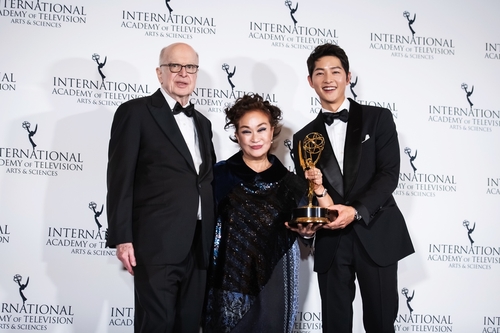 Lee Mie-kyung (C), vice chair of CJ Group, poses for a photo after receiving the International Emmy Directorate Award from the International Academy of Television Arts & Sciences (IATAS) during the 50th awards ceremony held in New York City on Nov. 21, 2022, along with Bruce L. Paisner (L), the IATAS president, and Korean actor Song Joong-ki (R), in this photo provided by CJ ENM. (PHOTO NOT FOR SALE) (Yonhap)