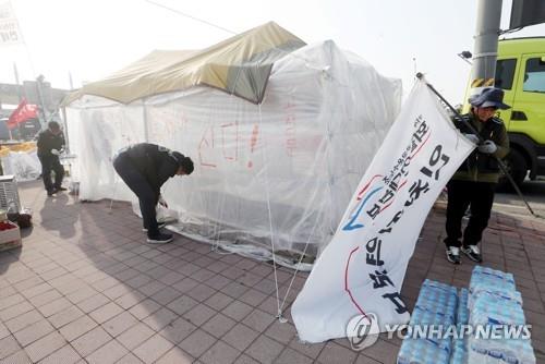 Cargo truckers pull down protest tents at a container terminal in Incheon on Dec. 9, 2022, after their union voted to end their weekslong strike. (Yonhap)