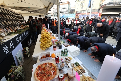 Bereaved families of the Itaewon crowd crush hold a memorial service for Lunar New Year near Noksapyeong Station in Seoul on Jan. 22, 2023. (Yonhap)