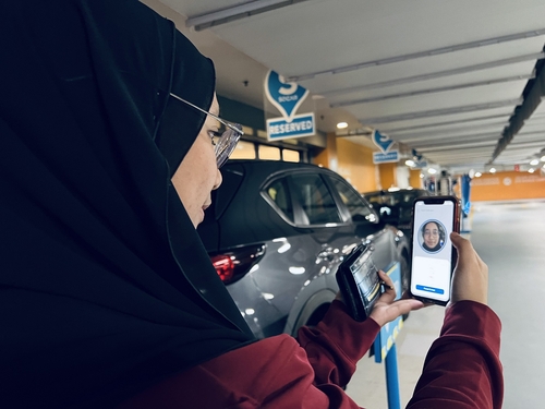 A woman uses the Socar car-sharing platform, backed by SK Inc., at a shopping mall in Bangsar, a suburb on the outskirts of Kuala Lumpur, in this photo provided by SK Inc. on March 16, 2023. (PHOTO NOT FOR SALE) (Yonhap) 