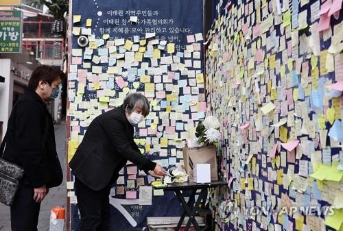 Kiyoshi Miki (R) and Seiji Shimomura, two of the family members of the victims of Japan's Akashi stampede, visit a memorial wall for the victims of the Halloween crowd crush in Itaewon, central Seoul, on March 17, 2023. (Yonhap)