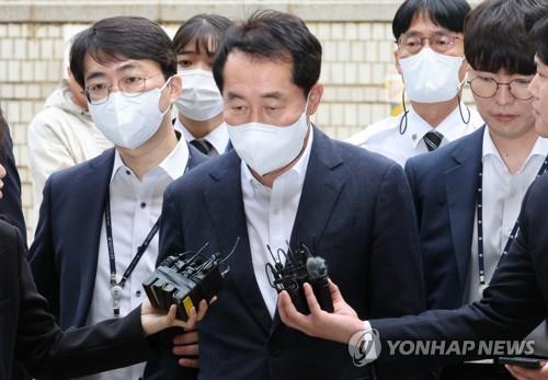 Kang Rae-gu (C), a sitting member of the audit committee for the state water agency K-water, heads to a hearing at the Seoul Central District Court in southern Seoul on April 21, 2023. (Yonhap)