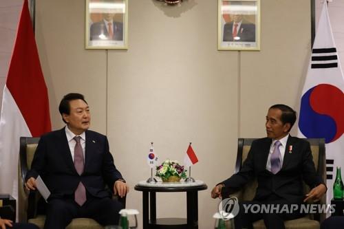 This file photo shows South Korean President Yoon Suk Yeol (L) chatting with Indonesian President Joko Widodo ahead of a South Korea-Indonesia business roundtable at Bali Nusa Dua Convention Center in Bali, Indonesia, on Nov. 14, 2022. (Yonhap)