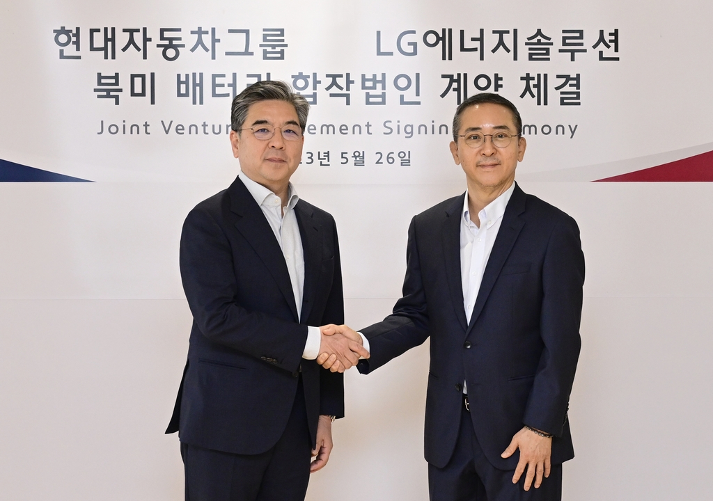 In this photo taken May 26, 2023, and provided by Hyundai Motor Group and LG Energy Solution Ltd., the group's President and CEO Chang Jae-hoon (L) shakes hands with the EV battery maker's CEO Kwon Young-soo after signing on their 5.7 trillion-won investment in a U.S. battery cell plant, at LG Energy Solution's headquarters in Yeouido, Seoul. (PHOTO NOT FOR SALE) (Yonhap)