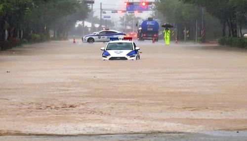 This photo provided by a reader shows a police car submerged in rainwater in the southern city of Gunsan on July 14, 2023. (PHOTO NOT FOR SALE) (Yonhap)