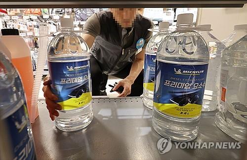 An employee at a discount store in Seoul checks stock of liquid urea on shelves on Sept. 8, 2023. (Yonhap)