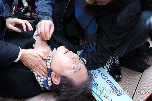 Lee Jae-myung, leader of the main opposition Democratic Party, lies down after he was attacked by an assailant on the left side of his neck during a visit to the construction site of an airport on Gadeok Island off the southeastern port city of Busan on Jan. 2, 2024. (Yonhap)