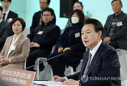 El presidente Yoon Suk Yeol (derecha) habla durante un debate público-gubernamental sobre cuestiones de medios de vida en un aeródromo de Seosan, a 98 kilómetros al suroeste de Seúl, el 26 de febrero de 2024. (Foto de la piscina) (Yonhap)