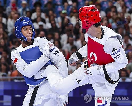 El atleta surcoreano Seo Gun-woo (derecha) compite contra el chileno Joaquín Churchill Martínez en los octavos de final de taekwondo masculino en los Juegos Olímpicos de París en la capital francesa el 9 de agosto de 2024. (Yonhap)