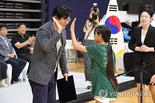 Seong Ghi-hong (izq.), director ejecutivo y presidente de la Agencia de Noticias Yonhap, saluda a un participante del Torneo Nacional Multicultural de Bádminton Familiar 2024 en el Gimnasio Goyang en la ciudad de Goyang, al norte de Seúl, el 24 de agosto de 2024 (Yonhap)