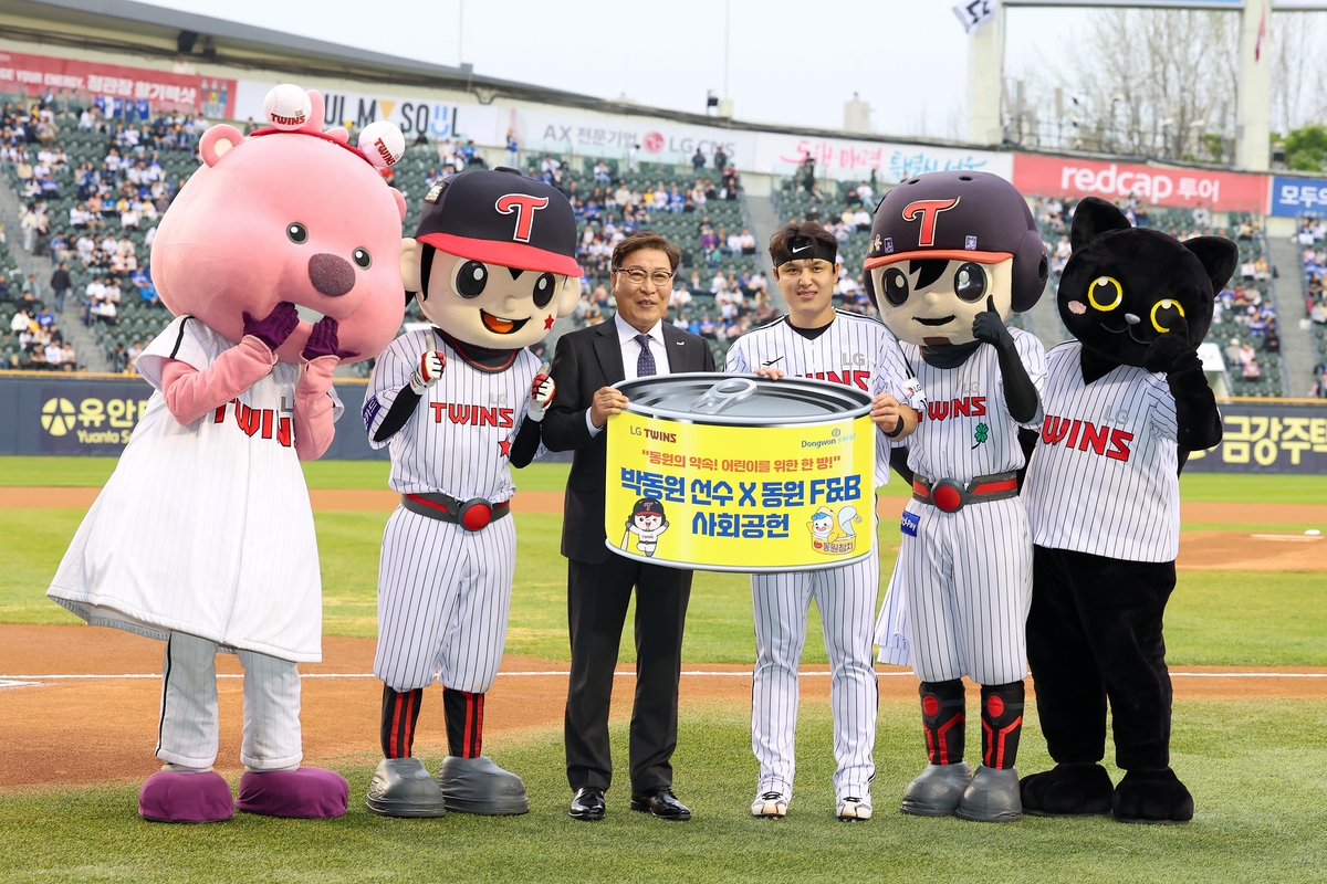 Park Dong-won of the LG Twins (3rd from R) poses with Dongwon F&B CEO Kim Sung-yong during a ceremony at Jamsil Baseball Stadium in Seoul marking the signing of a deal between the Twins and the foodmaker on April 17, 2025. Park will donate cash, and Dongwon F&B will offer its canned tuna products for every Park home run to underprivileged children. Photo provided by the Twins. (PHOTO NOT FOR SALE) (Yonhap)