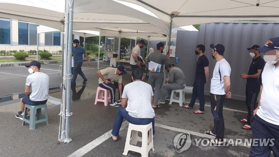 Des étrangers qui ont participé à un rassemblement musulman attendent de se faire dépister pour le nouveau coronavirus (Covid-19) devant un centre de test à Cheongju, dans la province du Chungcheong du Nord, le mercredi 5 août 2020.
