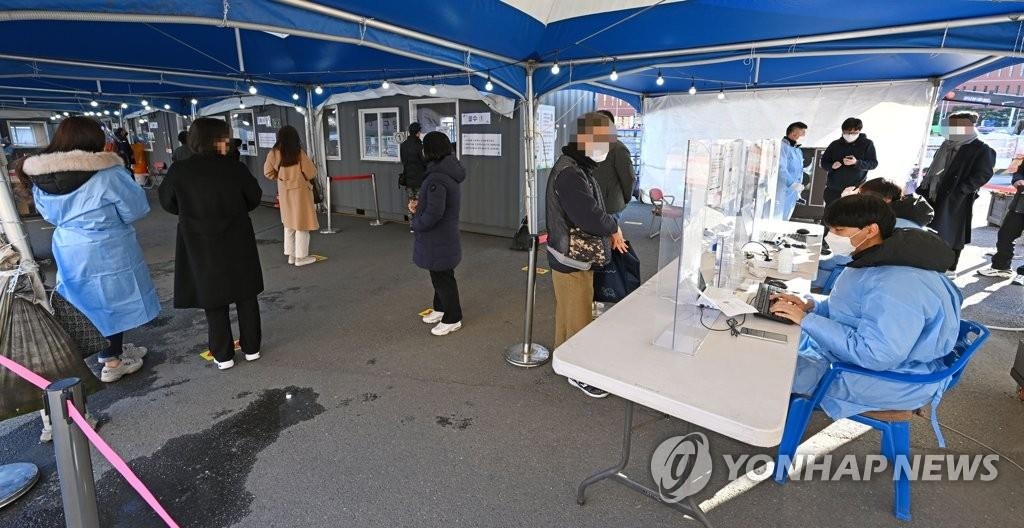 Des personnes attendent de subir un test de dépistage pour le nouveau coronavirus (Covid-19) dans un centre installé sur la place de la gare de Séoul, le vendredi 26 novembre 2021.