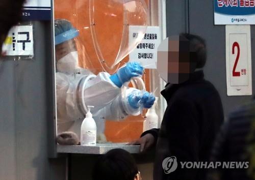 Un homme subit un test de dépistage pour le nouveau coronavirus (Covid-19) à Incheon, à l'ouest de Séoul, le lundi 6 décembre 2021. 