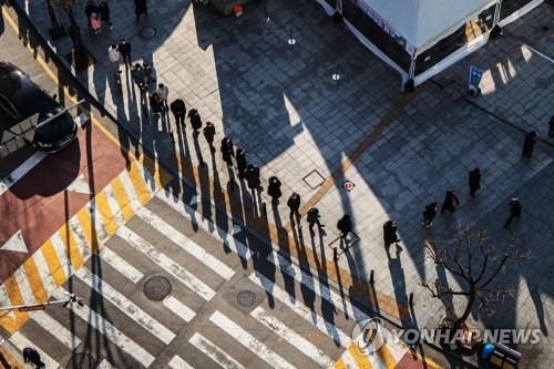 Les gens font la queue devant un centre de dépistage du nouveau coronavirus (Covid-19) à Goyang, dans la province du Gyeonggi, le 8 décembre 2021.
