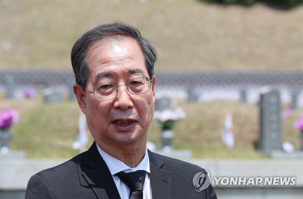 Le candidat au poste de Premier ministre Han Duck-soo se recueille au cimetière national du 18-Mai à Gwangju, le 17 mai 2022.