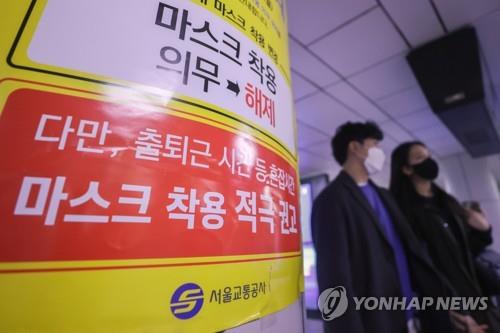 Une affiche indique que l'obligation de port du masque est levée mais reste fortement recommandée durant les heures de pointe dans les transports en commun, le lundi 20 mars 2023, dans une station de métro à Séoul. 