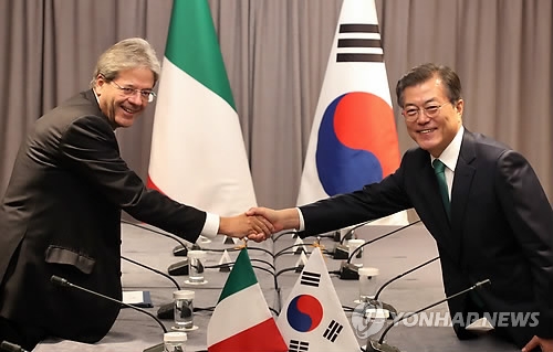 握手を交わす文大統領（右）とジェンティローニ首相＝２０日、ニューヨーク（聯合ニュース）
