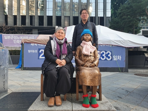 日本大使館前の少女像とキム夫妻＝（聯合ニュース）