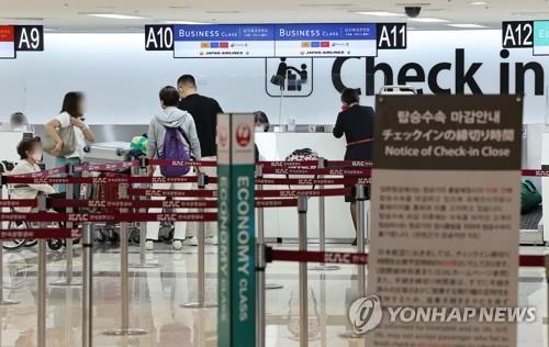 ２４日、金浦空港で羽田行きの飛行機の搭乗手続きをする乗客ら＝（聯合ニュース）