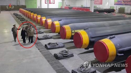 北朝鮮メディアは１日、金正恩氏（赤い線で囲んだ部分の手前右）が娘のジュエさんと火星１２を見て回る姿を公開した（朝鮮中央テレビの映像から）＝（聯合ニュース）≪転載・転用禁止≫