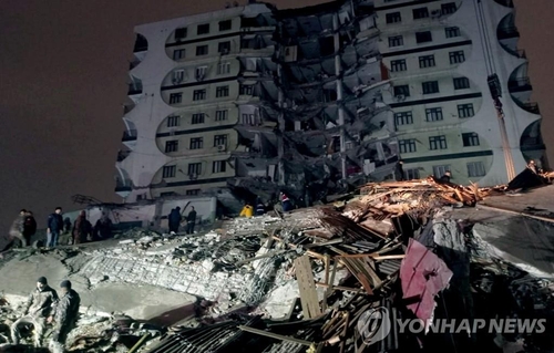 ６日に発生した地震で倒壊した南東部ディヤルバクルの建物で救助作業を行う人たち＝（ＥＰＡ＝聯合ニュース）
