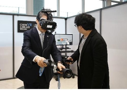 한양대 이영무 총장이 'VR 교육 도서관' 시연회에서 가상현실 실험을 하고 있다.