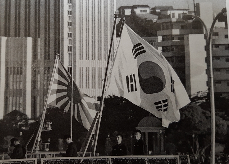 슈칸신초는 2015년 도쿄 하루미항에 정박한 한국 구축함이 일제 전범기로 불리는 '욱일기'(교쿠지쓰키)를 단 해상자위대 함정과 나란히 있는 장면이라고 이 사진을 게재했다. 당시 한국군은 욱일기에 신경 쓰지 않고 관대한 태도를 보였다고 했다. [잡지 촬영]
