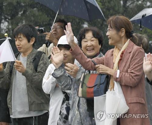 22일 오전 8시16분께 즉위 의식에 참석하기 위해 도쿄 왕궁으로 들어가는 나루히토 일왕이 탄 차량을 향해 일본 시민들이 손을 흔들고 있다. [교도=연합뉴스]