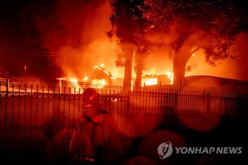 31일 미 캘리포니아주 샌버나디노에서 발생한 힐사이드 파이어로 주택이 불에 타고 있다. [AFP=연합뉴스]