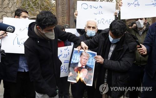 지난 28일 이란 테헤란의 외교부 앞에서 핵과학자 모센 파크리자데에 대한 테러에 항의해 도널드 트럼프 미국 대통령과 조 바이든 당선인의 사진을 태우는 학생들[EPA=연합뉴스]