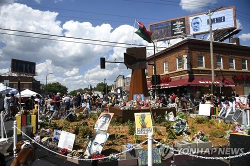 흑인 조지 플로이드가 숨진 미 미네소타 미니애폴리스의 거리에 25일 사람들이 모여 그의 1주기를 기념하고 있다. 플로이드가 숨진 이곳에는 '조지플로이드 스퀘어'란 이름이 붙여졌다. [EPA=연합뉴스] 