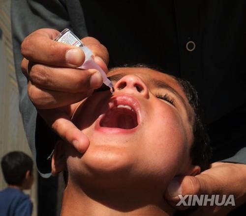  아프간 어린이에게 소아마비 백신을 투여하는 모습