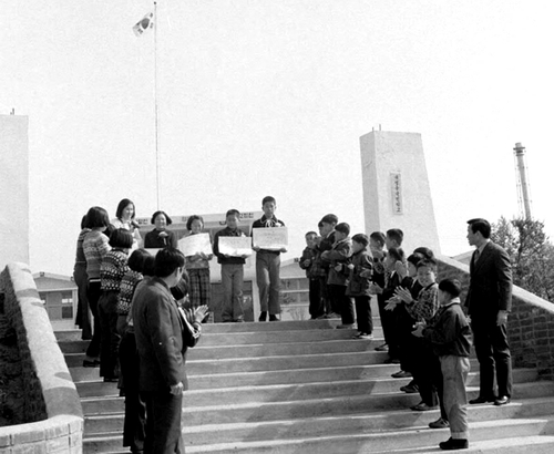 DMZ 안에 있는 경기도 파주 대성동초등학교 졸업식에서 졸업생들이 재학생의 박수를 받으며 교문을 나서고 있다. 1974년 [국가기록원 제공]