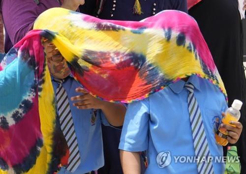 4월 21일 태양열을 피하려고 스카프로 머리를 가린 인도 프라야그라지의 학생