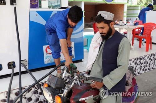 아프가니스탄 칸다하르에서 오토바이에 주유하는 한 남성(오른쪽)