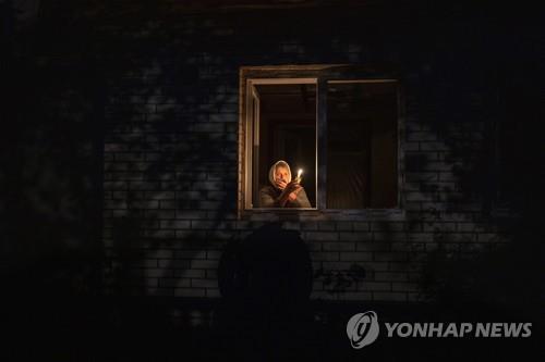 전력 공급이 끊겨 촛불로 불을 밝히는 우크라이나 수도 키이우 주민 [AP 연합뉴스 자료사진. 재판매 및 DB 금지] 