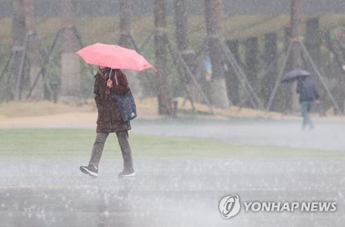 광화문광장을 지나는 시민들이 갑자기 쏟아지는 비를 뚫고 걸어가고 있다. [연합뉴스 자료사진] 