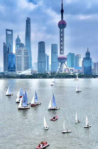 The sailboats on the Huangpu River flow like a moving scroll,