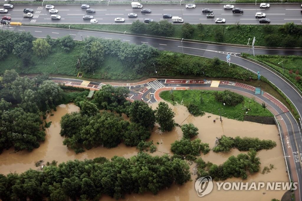 Partes de una carretera y un parque de ribera al lado de la autopista Olímpica en el sur de Seúl se ven inundados, el 3 de agosto de 2020, debido a las fuertes lluvias.
