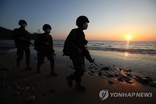 En la fotografía de archivo, los infantes de marina surcoreanos patrullan una playa de la isla fronteriza occidental de Yeonpyeong, el 28 de septiembre de 2020, en medio de las tensiones por el asesinato de un funcionario surcoreano por parte de Corea del Norte en sus aguas, el 22 de septiembre.