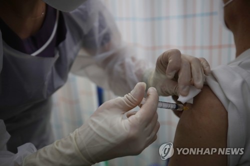 Un trabajador sanitario administra a un ciudadano una inyección de la vacuna contra el COVID-​19, el 7 de junio de 2021, en Seúl.