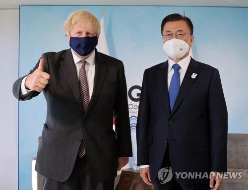 El presidente surcoreano, Moon Jae-in (dcha.), y el primer ministro británico, Boris Johnson, posan para una fotografía, antes de sostener su reunión cumbre bilateral, el 13 de junio de 2021, en el condado británico de Cornualles, al margen de la cumbre del G-7.