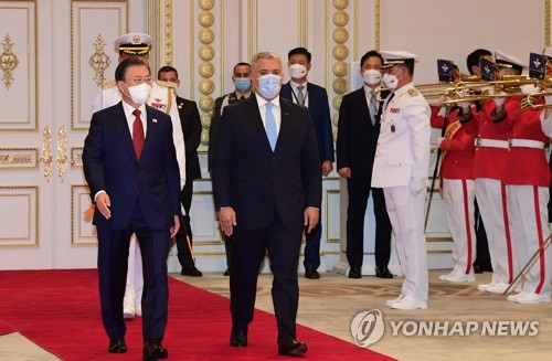 El presidente surcoreano, Moon Jae-in (izda.), y su homólogo colombiano, Iván Duque Márquez, pasan revista a una guardia de honor durante una ceremonia para dar la bienvenida a Duque por su visita de Estado a Corea del Sur, celebrada, el 25 de agosto de 2021, en la oficina presidencial, Cheong Wa Dae, en Seúl. 