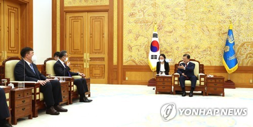 El presidente surcoreano, Moon Jae-in (dcha.), conversa con el ministro de Asuntos Exteriores de China, Wang Yi (segundo por la izda.), el 15 de septiembre de 2021, en la oficina presidencial, Cheong Wa Dae, en Seúl.