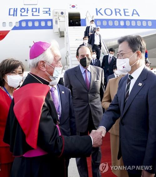 El presidente surcoreano, Moon Jae-in (dcha.), es recibido por un representante del Vaticano, el 28 de octubre de 2021 (hora local), a su llegada al Aeropuerto de Roma-Fiumicino, en Italia, para reunirse con el papa Francisco y celebrar una cumbre del Grupo de los 20 (G-20). 