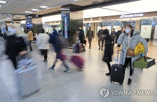 Los viajeros llegan al Aeropuerto Internacional de Jeju, en la isla sureña del mismo nombre, el 28 de enero de 2022, antes de la festividad prolongada del Año Nuevo Lunar.