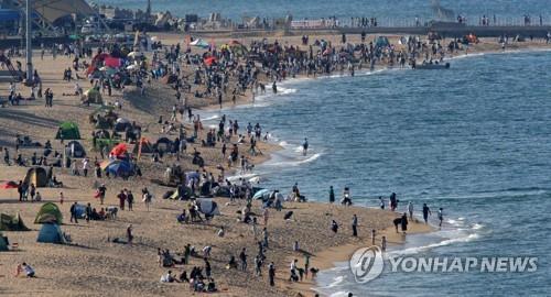 La foto, tomada el 5 de mayo de 2022, muestra una playa abarrotada de personas, en la ciudad costera oriental de Sokcho, en la provincia de Gangwon. 